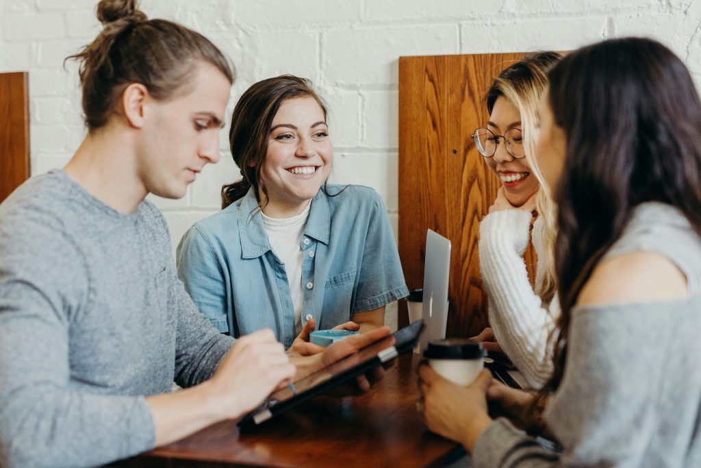 Young coworkers sitting around a table smiling